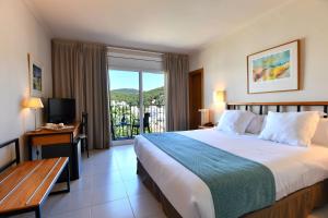 a hotel room with a large bed and a balcony at Hotel Hostalillo by Escampa Hotels in Tamariu