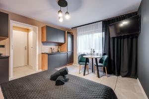 a bedroom with a bed and a kitchen with a table at Loft House Apartment Studio z ogródkiem 1 in Rybnik