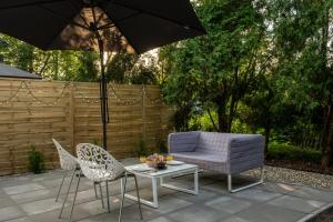 a patio with a table and chairs and an umbrella at Loft House Apartment Studio z ogródkiem 1 in Rybnik