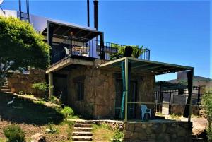 ein Haus mit einer Terrasse und einem Balkon in der Unterkunft LA PEDRERA - ESPECTACULARES VISTAS - Carlos Paz - Córdoba - Argentina in Villa Carlos Paz