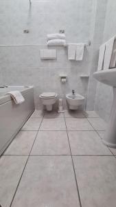 Baño blanco con aseo y lavamanos en PEDA Hotel Ristorante Pizzeria, en Colletorto