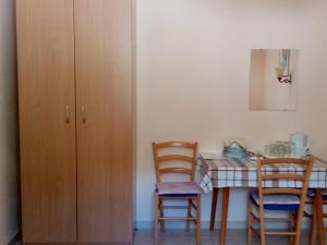 cocina con mesa, sillas y armario en Rooms MUDRAC en Senj