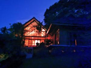 ein nachts beleuchtetes Haus in der Unterkunft Camiguin Volcano Houses-Panoramic House in Mambajao