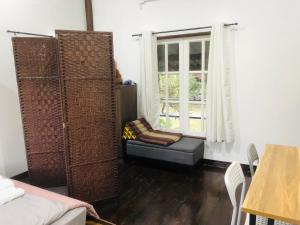 a living room with a couch and a window at Bo Cabin in Garden โบคาบิน อิน การ์เดน in Ban Nong Ki