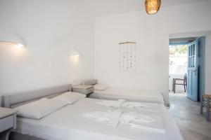a bedroom with a white bed with towels on it at Hotel Mantalena in Antiparos Town
