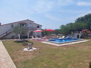 a yard with a swimming pool and a house at Apartments Chipo in Vodnjan