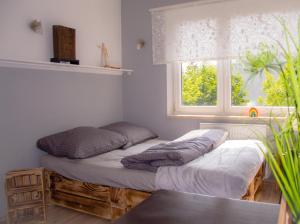 dwa łóżka ustawione w pokoju z oknem w obiekcie Apartament Grunwaldzka przy Łynie w Olsztynie