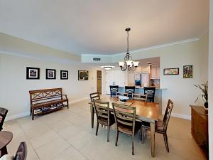 a dining room and living room with a table and chairs at Portofino Island Resort #5-1403 in Pensacola Beach