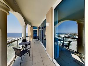 a balcony with chairs and tables and a view of the ocean at Port51403 in Pensacola Beach