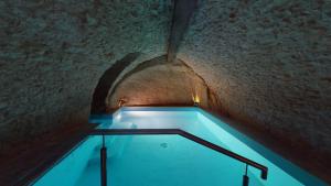 einen Pool in einem Gebäude mit einer Decke in der Unterkunft Chapel Cottage in La Bachellerie