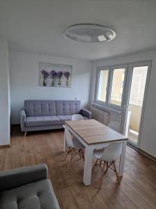 a living room with a table and a couch at Apartament Lawendowy Gdańsk in Gdańsk