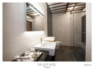 ein Badezimmer mit einem weißen Waschbecken und einem Spiegel in der Unterkunft The Loft Hotel Downtown Yangon in Yangon + 28 Fotos