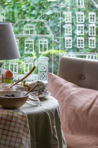 a table with a bowl of food and a lamp on it at De Roos Leeuwarden in Leeuwarden