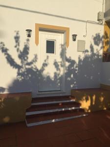 a door with a shadow of trees on a wall at Casa Janeiro Alentejo in Portalegre