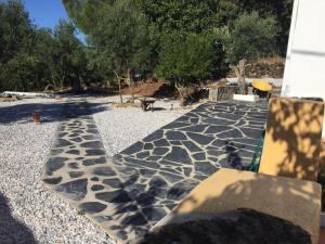 a stone walkway with a bench in a yard at Casa Janeiro Alentejo in Portalegre
