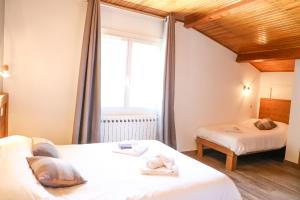 1 dormitorio con 2 camas y ventana en Le Sans Souci en Jausiers