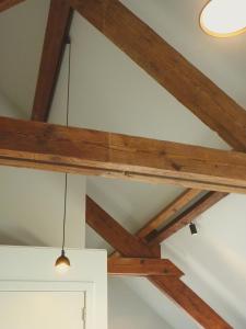 a ceiling with wooden beams and a light fixture at Site78 in Puurs