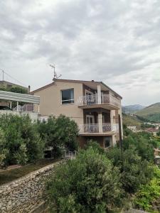a house with a balcony on top of a hill at Apartment Pupina in Žrnovnica