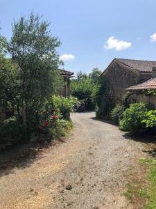 a dirt road leading to a house with flowers at Holli cottage - Charming 2 bedrooms with terrace. in Saint-Avit-Rivière