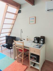 Zimmer mit einem Schreibtisch, einem Computer und einem TV. in der Unterkunft Cosy Studio en résidence privée in Marseille