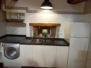 a kitchen with a sink and a refrigerator at Casa Rural del Acebo in Espinoso de Compludo