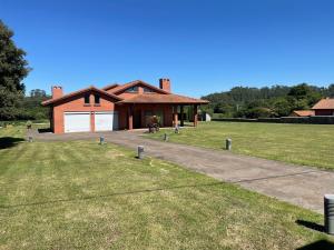 a house with a garage and a grass yard at Villa Monasterio in Camargo