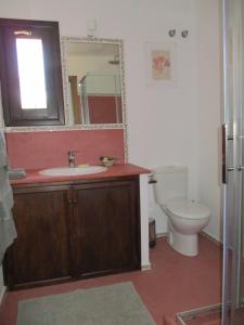 bagno con lavandino, servizi igienici e specchio di Casa Laibon a Gaucín