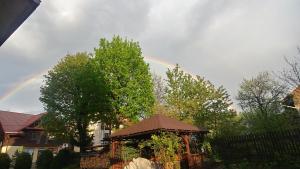 a rainbow in the sky over a house with a gazebo at Pokoje "na Pierniku" in Szczawnica