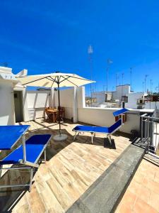patio con sedie blu e ombrellone sul tetto di Apulia Holidays a Mola di Bari