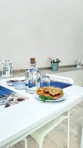 a white table with a plate of food on it at Coastal B&B San Vito Lo Capo in San Vito lo Capo