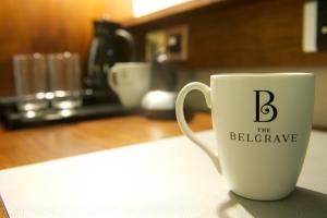 a white coffee cup with the letter b on it at The Belgrave Hotel in London