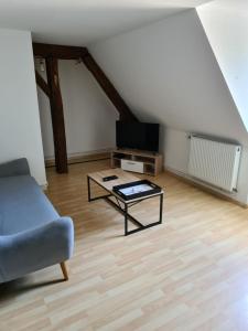 a living room with a couch and a table at Aux remparts du château in Sedan