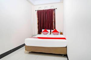 a bed in a room with a window at OYO 91322 Jawara Guest House Syariah in Bandung