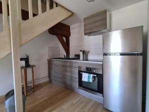 a kitchen with a stainless steel refrigerator and a staircase at Aux remparts du château in Sedan