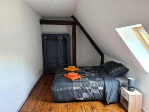 ein Schlafzimmer mit einem Bett mit orangefarbenen Handtüchern darauf in der Unterkunft Aux remparts du château in Sedan