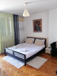 een slaapkamer met een groot bed met witte lakens bij Apartman Centar Beograd in Belgrado