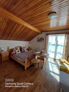 a bedroom with a bed and a wooden ceiling at Pokoje v šumavském domě in Nové Hutě