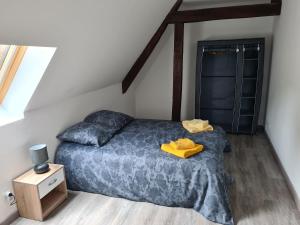 ein Schlafzimmer mit einem Bett und einem gelben Bademantel darauf in der Unterkunft Aux remparts du château in Sedan