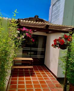 un patio con un banco y flores en un edificio en Hotel CSI Llanogrande, en Rionegro