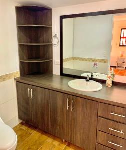 a bathroom with a sink and a mirror at Hotel CSI Llanogrande in Rionegro