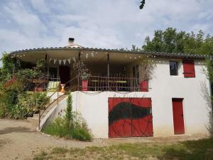 een wit huis met rode deuren en een hek bij Villa forest home avec piscine dans les gorges du verdon en Provence in Quinson