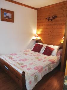 a bedroom with a bed with a wooden wall at appartement Ancolie in Saint-Martin-de-Belleville