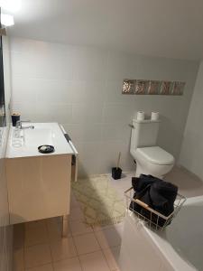 a bathroom with a sink and a toilet and a tub at Les Mirabelles in Tournon-dʼAgenais