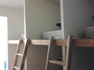 a bedroom with a bunk bed and two wooden chairs at Herbaceous-Inn in Nanwan