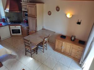 a small kitchen with a wooden table and chairs at Les Gites de TY Dreux Monts d'arrée in Saint-Thégonnec +17 photos