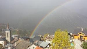 a rainbow over a city with a town with buildings at appartement Ancolie in Saint-Martin-de-Belleville