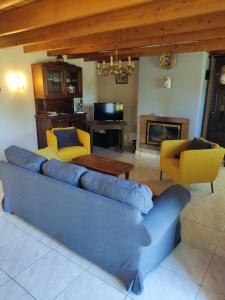 ein Wohnzimmer mit einem blauen Sofa und gelben Stühlen in der Unterkunft Les Gites de TY Dreux Monts d'arrée in Saint-Thégonnec