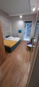 a bedroom with a bed and a wooden floor at Apartament Oaza Jastrzębia Góra in Jastrzębia Góra