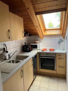 a kitchen with a sink and a microwave at Ferienwohnung Landsberg am Lech in Landsberg am Lech