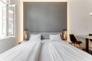 2 camas blancas en una habitación con silla en Lampi Hotel Prague en Praga